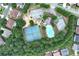 An aerial view showing tennis courts and a pool surrounded by trees at 1146 Simonton Peak Way, Lawrenceville, GA 30045