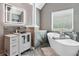 This modern bathroom boasts a soaking tub, herringbone tile, and sleek vanity at 1146 Simonton Peak Way, Lawrenceville, GA 30045
