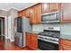 Spacious kitchen features wooden cabinetry, stainless steel appliances, and granite countertops at 1146 Simonton Peak Way, Lawrenceville, GA 30045