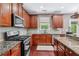 Spacious kitchen features wooden cabinetry, stainless steel appliances, granite countertops, and modern fixtures at 1146 Simonton Peak Way, Lawrenceville, GA 30045