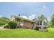 Brick home exterior with a screened-in porch and lush green lawn, providing a relaxing outdoor living space at 1725 Mountainside Dr, Cumming, GA 30040