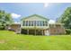 Rear exterior view of home with a screened-in porch and large green lawn, perfect for outdoor gatherings at 1725 Mountainside Dr, Cumming, GA 30040