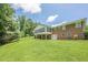 Spacious backyard featuring a brick home with a screened-in porch and large green lawn, offering privacy and space at 1725 Mountainside Dr, Cumming, GA 30040