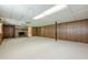 Basement with brick fireplace, carpet flooring, and wood panel walls, creating a cozy and versatile space at 1725 Mountainside Dr, Cumming, GA 30040