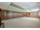 Large basement featuring wood-paneled walls, drop ceiling, and carpet flooring, ideal for recreation or storage at 1725 Mountainside Dr, Cumming, GA 30040