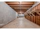 Unfinished basement with exposed beams, block walls, concrete floor, and shelving, offering ample storage potential at 1725 Mountainside Dr, Cumming, GA 30040