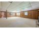 Spacious basement with carpet flooring, wood panel walls, and a drop ceiling, offering potential for various uses at 1725 Mountainside Dr, Cumming, GA 30040