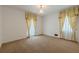 Bedroom with beige carpet, white walls, and windows with patterned yellow curtains at 1725 Mountainside Dr, Cumming, GA 30040