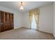 A neutral carpeted bedroom features dark wood closet doors and light yellow curtains at 1725 Mountainside Dr, Cumming, GA 30040