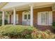 Close up view of a brick home featuring a welcoming front porch with detailed columns and double doors at 1725 Mountainside Dr, Cumming, GA 30040
