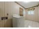 A vintage laundry room with a front-loading washing machine, floral wallpaper and tile flooring at 1725 Mountainside Dr, Cumming, GA 30040