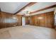 Open living room featuring wood-paneled walls, carpeted floors, and exposed wood beams at 1725 Mountainside Dr, Cumming, GA 30040