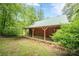 View of the outbuilding with porch and swing, surrounded by trees and greenery at 1725 Mountainside Dr, Cumming, GA 30040