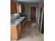 Galley kitchen featuring stainless steel appliances, wood cabinets, and granite countertops at 1947 Kensington High Sw St, Lilburn, GA 30047