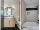 Brightly lit bathroom with dual sink vanity and tub with shower at 3960 Clairmont Rd # 2, Chamblee, GA 30341