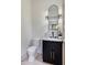 Stylish powder room featuring a marble countertop, black vanity, and elegant mirror with sconces at 3960 Clairmont Rd # 2, Chamblee, GA 30341