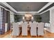 Sophisticated dining room with elegant chandelier, dark walls, white trim and a large table set for a formal dinner at 5995 Ettington Dr, Suwanee, GA 30024