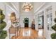 Light-filled foyer showcasing hardwood floors, a statement chandelier, and views into adjacent living spaces at 5995 Ettington Dr, Suwanee, GA 30024