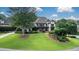 Attractive exterior showcasing meticulous landscaping around a two-story home with a stone facade and mature shade trees at 5995 Ettington Dr, Suwanee, GA 30024