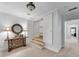 Hallway with decorative table and mirror, leading to stairs and additional rooms at 5995 Ettington Dr, Suwanee, GA 30024
