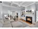 Inviting living room featuring a cozy fireplace, built-in shelves, and comfortable seating with a view to the dining room at 5995 Ettington Dr, Suwanee, GA 30024