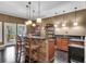 Wet bar featuring stone accents, bar seating, pendant lights, and dark hardwood floors at 5995 Ettington Dr, Suwanee, GA 30024