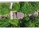 Aerial view of a home with a backyard lawn, fire pit, and a long driveway surrounded by trees at 4745 Masters Ct, Duluth, GA 30096