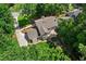 Aerial view of a home with a large lawn, patio, and a long driveway surrounded by mature trees at 4745 Masters Ct, Duluth, GA 30096