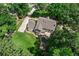 Aerial view of a home with a backyard lawn, patio, and long driveway surrounded by mature trees at 4745 Masters Ct, Duluth, GA 30096