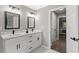 Bathroom with double vanity, two mirrors, and an adjacent open door to a bedroom suite at 4745 Masters Ct, Duluth, GA 30096
