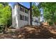 Charming home with white brick and dark shutters, complemented by lush landscaping and mature trees at 4745 Masters Ct, Duluth, GA 30096