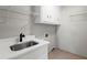 Functional laundry room with sink, storage cabinets, and tiled floor at 4745 Masters Ct, Duluth, GA 30096