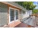 Back exterior view of the house with glass doors, brick wall, and a small patio at 935 Bobcat Se Ct, Marietta, GA 30067