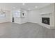 Spacious living room featuring a white brick fireplace, gray flooring, and seamless access to the kitchen at 935 Bobcat Se Ct, Marietta, GA 30067