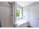 Bathroom with white tub and shower combo, neutral walls, and window with natural light at 108 Spring View Br, Dallas, GA 30157