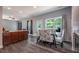 Open dining area with a glass table, modern chairs, wood floors, and access to the backyard at 108 Spring View Br, Dallas, GA 30157