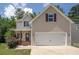 Charming two-story home featuring a covered porch, two-car garage, and tasteful neutral siding at 108 Spring View Br, Dallas, GA 30157