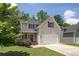 Charming two-story home featuring a covered porch, two-car garage, and tasteful neutral siding at 108 Spring View Br, Dallas, GA 30157