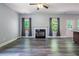 Open living room featuring a fireplace, large windows, stylish flooring, and an open concept design at 108 Spring View Br, Dallas, GA 30157