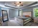 Spacious primary bedroom featuring a tray ceiling, ceiling fan, and large bed with side tables at 108 Spring View Br, Dallas, GA 30157