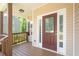 Inviting covered porch with a dark wood door, sidelights, and a stained wood deck and railing at 108 Spring View Br, Dallas, GA 30157