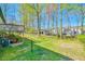 Spacious backyard with green grass, mature trees, and a deck at 5774 Harbor Dr, Buford, GA 30518