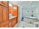 Well-lit bathroom featuring a corner tub with tile surround, and wood cabinets at 5774 Harbor Dr, Buford, GA 30518