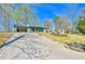 Ranch home with well-manicured front yard and a long driveway leading to an attached garage at 5774 Harbor Dr, Buford, GA 30518