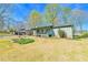 Single-story home with covered porch, open garage, and a well-maintained lawn and landscaping at 5774 Harbor Dr, Buford, GA 30518