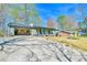Single-story home with a covered front porch, open garage, and spacious driveway at 5774 Harbor Dr, Buford, GA 30518