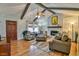 Cozy living room featuring vaulted ceilings, a stone fireplace, and stylish decor at 5774 Harbor Dr, Buford, GA 30518