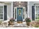 Close-up of an elegant front door with sidelights, decorative stone surround, and potted plants at 2429 Brookgreen Nw Commons, Kennesaw, GA 30144