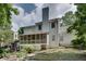 Back exterior showcasing a neutral color, chimney, screened in porch, and backyard with mature trees at 2429 Brookgreen Nw Commons, Kennesaw, GA 30144