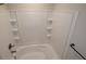 Bathroom featuring a tiled shower and tub combo with built-in shelving at 3484 Enterkin Ln, Atlanta, GA 30349